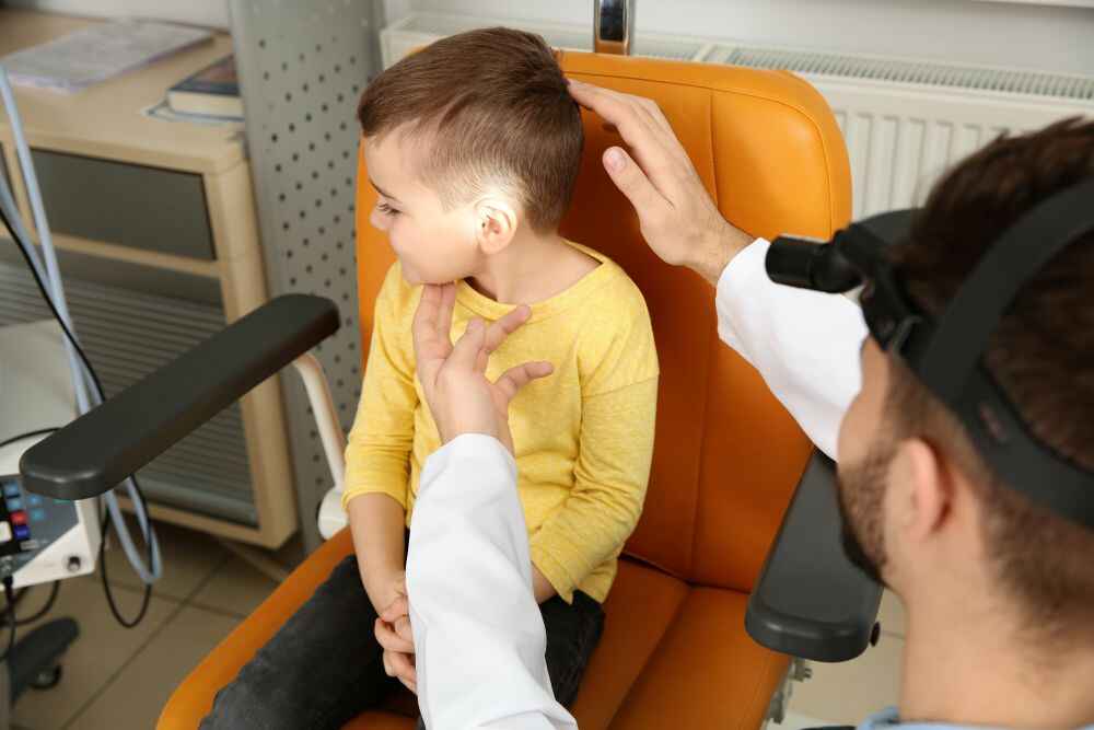 ENT doctor checking pediatric patient's ear