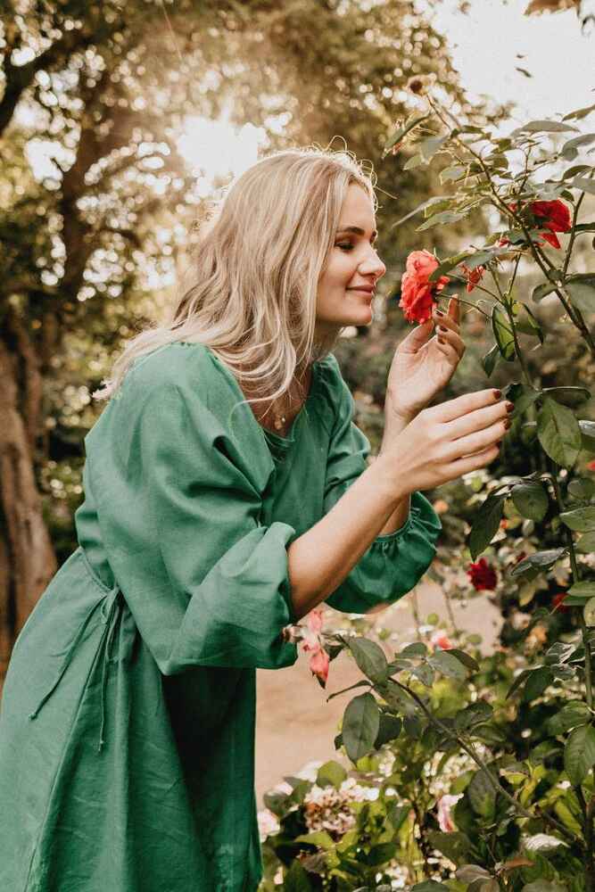 Woman smelling flowers after being relieved from allergy symptoms